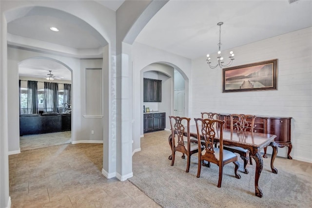 dining space featuring a chandelier, arched walkways, and baseboards