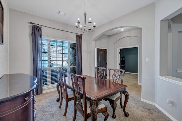 dining space with arched walkways, light carpet, visible vents, baseboards, and an inviting chandelier