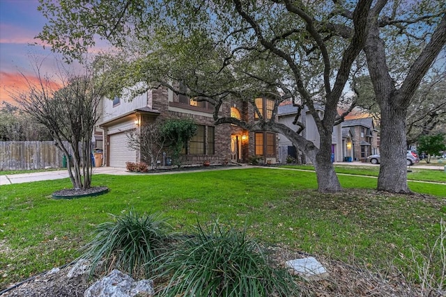 view of front of home featuring a yard, fence, a garage, and driveway