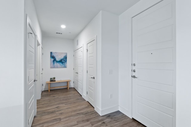 foyer with baseboards, visible vents, dark wood-style flooring, and recessed lighting