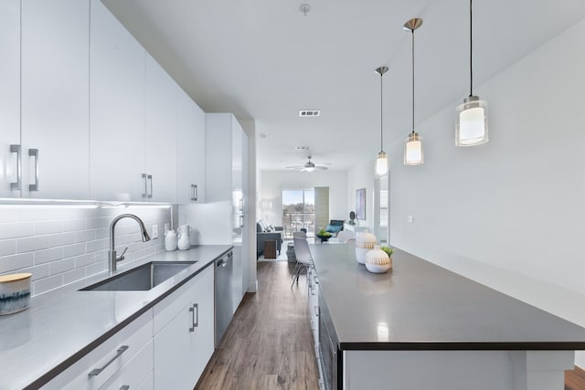 6444 Burnet Rd Unit 308, Austin, TX 78757 - kitchen with white cabinets, backsplash, wood finished floors, and a ceiling fan