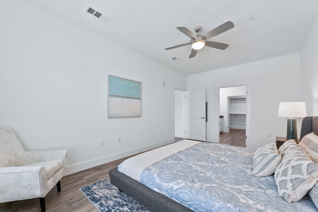 6444 Burnet Rd Unit 308, Austin, TX 78757 - bedroom featuring wood finished floors, a spacious closet, and a ceiling fan