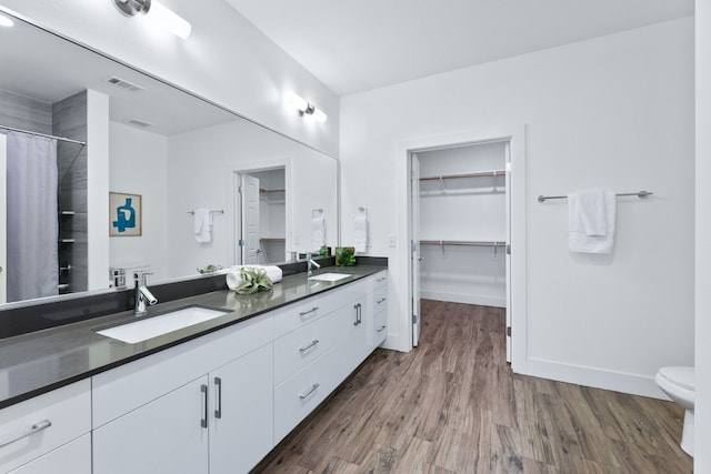 6444 Burnet Rd Unit 308, Austin, TX 78757 - full bath featuring double vanity, wood finished floors, a spacious closet, and a shower with curtain