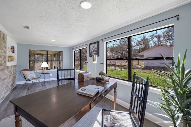 office area featuring a textured ceiling, wood finished floors, visible vents, baseboards, and ornamental molding