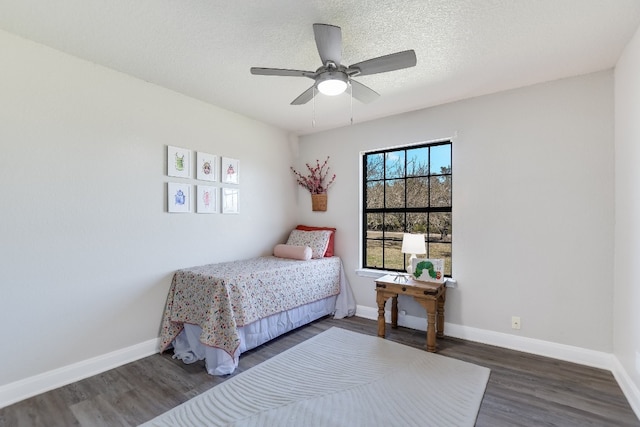 bedroom with dark wood-style floors, ceiling fan, a textured ceiling, and baseboards