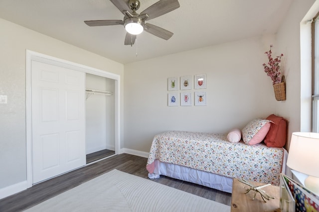 bedroom with ceiling fan, dark wood-style flooring, a closet, and baseboards