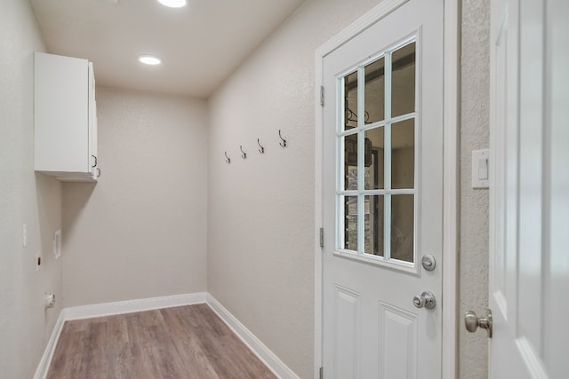 doorway to outside featuring light wood finished floors, baseboards, and recessed lighting