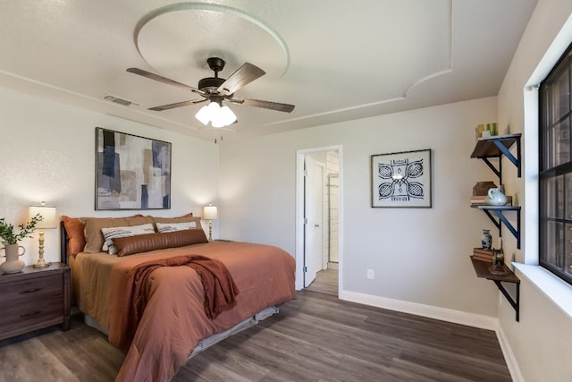 bedroom with visible vents, dark wood-style flooring, a ceiling fan, and baseboards