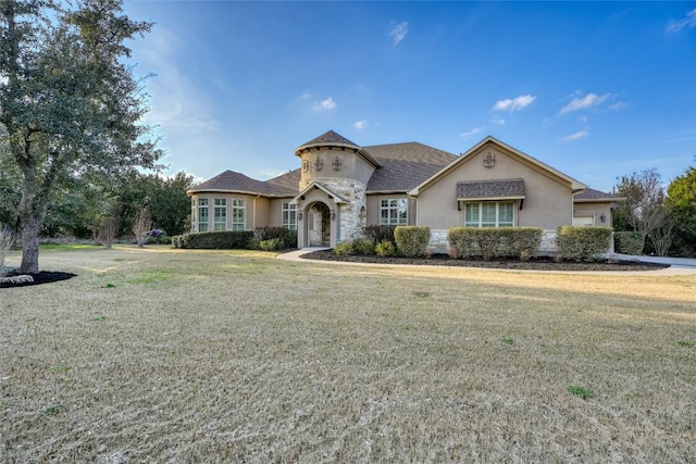 view of front of house featuring stone siding, a front yard, and stucco siding