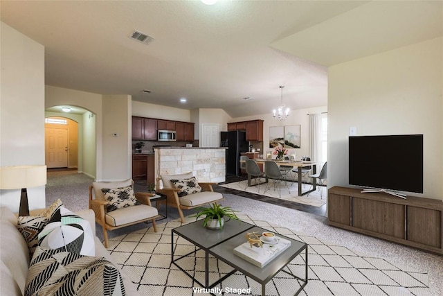 living room featuring arched walkways, light carpet, visible vents, and a notable chandelier