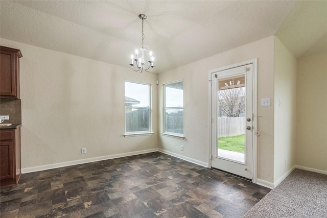 214 Teron Dr, San Marcos, TX 78666 - unfurnished dining area with a notable chandelier, lofted ceiling, and stone finish flooring