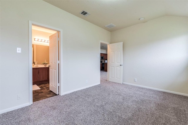 214 Teron Dr, San Marcos, TX 78666 - unfurnished bedroom featuring visible vents, dark colored carpet, vaulted ceiling, and baseboards