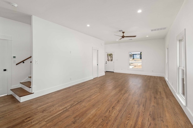 unfurnished living room with recessed lighting, dark wood-style flooring, visible vents, baseboards, and stairway