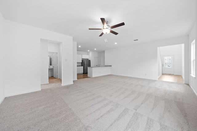 unfurnished living room with baseboards, recessed lighting, a ceiling fan, and light colored carpet