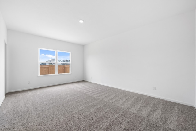 unfurnished room with carpet and baseboards