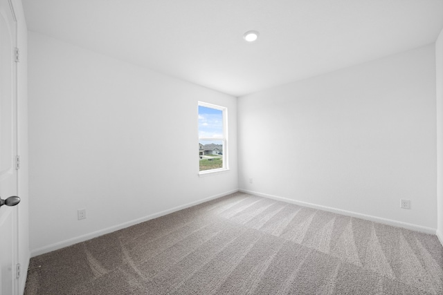 unfurnished room with carpet and baseboards