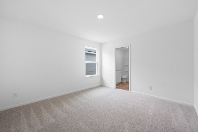 spare room with recessed lighting, light carpet, and baseboards