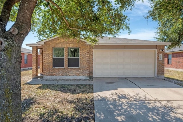 ranch-style home featuring a garage, brick siding, and driveway