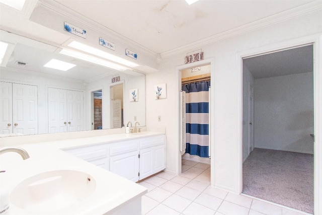 bathroom featuring tile patterned flooring, crown molding, a sink, and double vanity