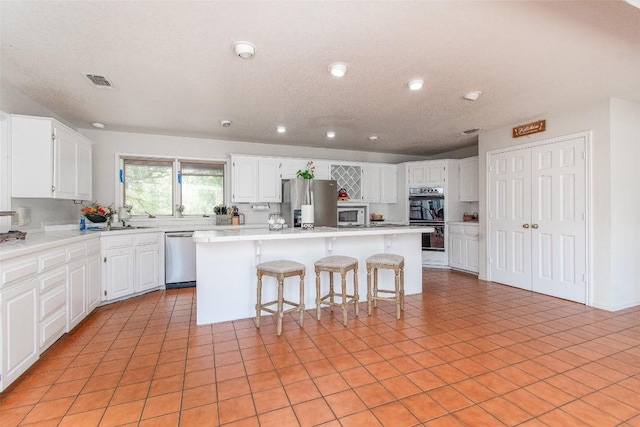 1414 Eagle Trl, Copperas Cove, TX 76522 - kitchen featuring appliances with stainless steel finishes, a kitchen island, recessed lighting, a kitchen bar, and white cabinetry