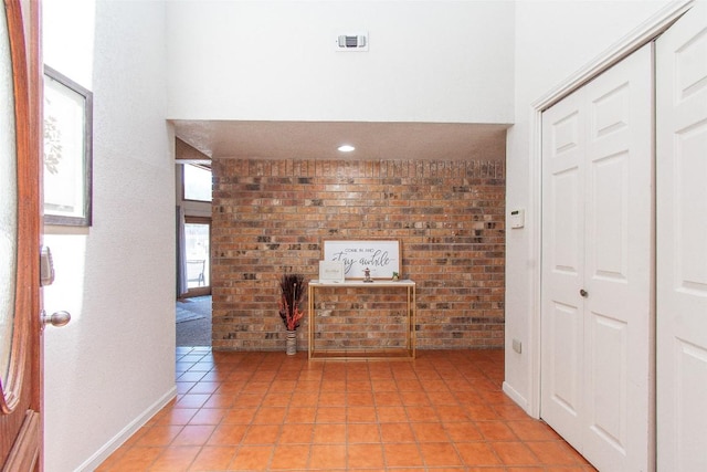 1414 Eagle Trl, Copperas Cove, TX 76522 - unfurnished living room with brick wall, light tile patterned flooring, and a high ceiling