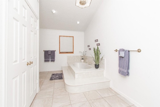 bathroom with lofted ceiling, baseboards, a bath, and tile patterned floors