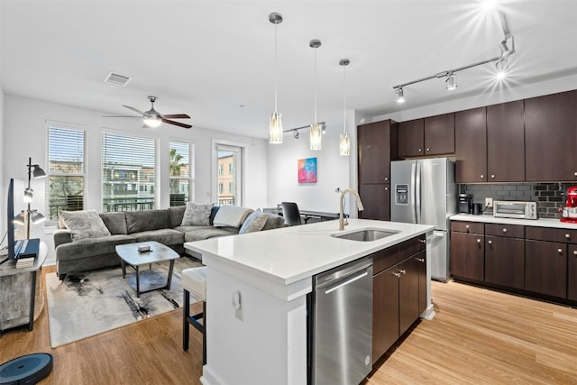 kitchen with visible vents, open floor plan, light countertops, appliances with stainless steel finishes, and an island with sink