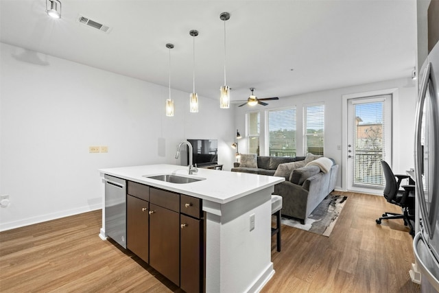 1900 Barton Springs Rd Unit 4040, Austin, TX 78704 - kitchen featuring appliances with stainless steel finishes, light wood-style floors, light countertops, and dark brown cabinetry