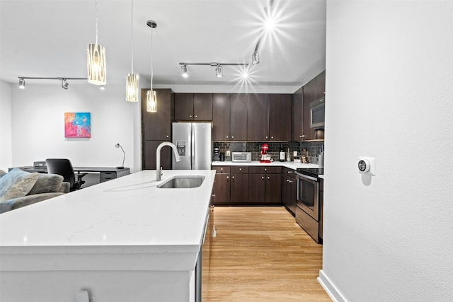 1900 Barton Springs Rd Unit 4040, Austin, TX 78704 - kitchen featuring appliances with stainless steel finishes, track lighting, dark brown cabinets, and decorative backsplash