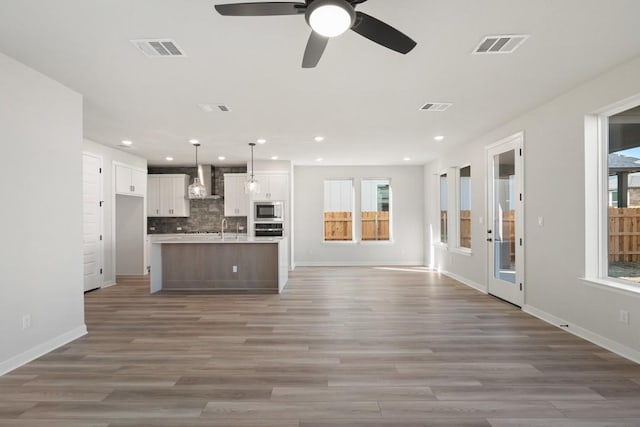 1205 N Roger Hanks Pkwy, Dripping Springs, TX 78620 - kitchen with a center island with sink, stainless steel appliances, visible vents, open floor plan, and white cabinets
