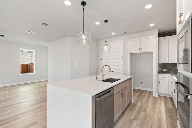 1205 N Roger Hanks Pkwy, Dripping Springs, TX 78620 - kitchen featuring a sink, white cabinetry, light countertops, appliances with stainless steel finishes, and a center island with sink