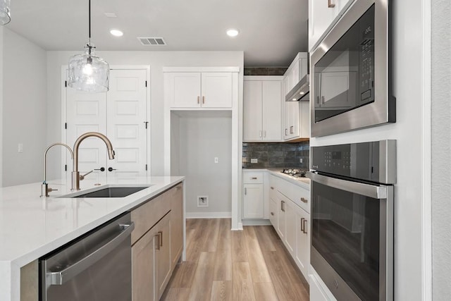 1205 N Roger Hanks Pkwy, Dripping Springs, TX 78620 - kitchen with white cabinetry, stainless steel appliances, a sink, and pendant lighting