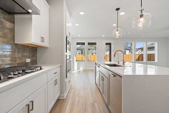 1205 N Roger Hanks Pkwy, Dripping Springs, TX 78620 - kitchen featuring light countertops, an island with sink, wall chimney exhaust hood, and white cabinets