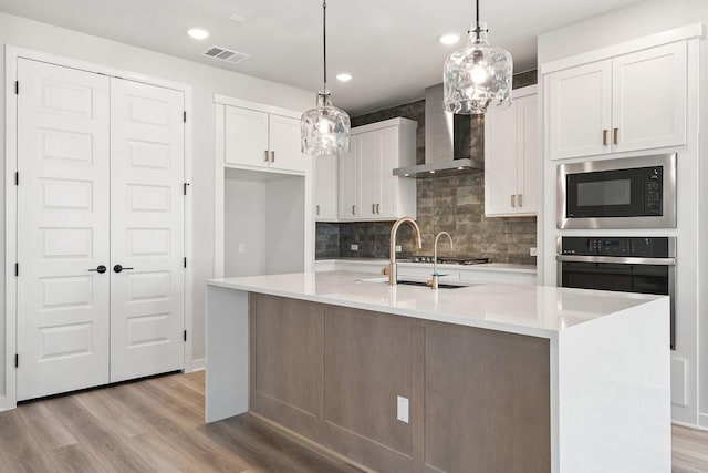 1205 N Roger Hanks Pkwy, Dripping Springs, TX 78620 - kitchen featuring light countertops, white cabinets, a kitchen island with sink, and wall chimney exhaust hood