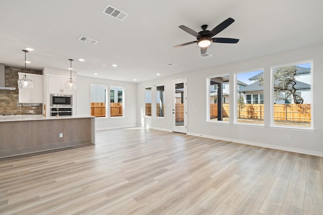 1205 N Roger Hanks Pkwy, Dripping Springs, TX 78620 - unfurnished living room with visible vents, light wood-style flooring, and baseboards