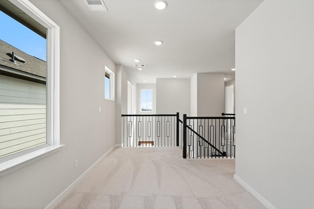 1205 N Roger Hanks Pkwy, Dripping Springs, TX 78620 - hallway featuring carpet floors, baseboards, visible vents, and an upstairs landing
