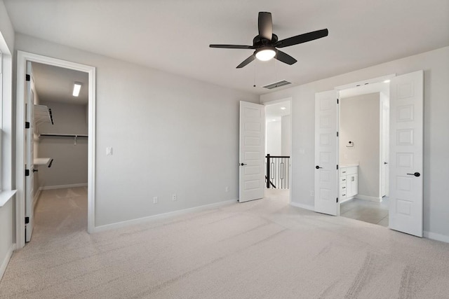 1205 N Roger Hanks Pkwy, Dripping Springs, TX 78620 - unfurnished bedroom with light carpet, baseboards, visible vents, ensuite bathroom, and a spacious closet