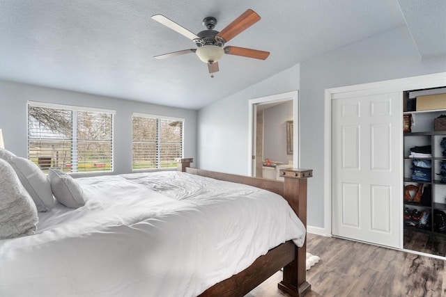 bedroom featuring ensuite bathroom, a ceiling fan, vaulted ceiling, a textured ceiling, and wood finished floors