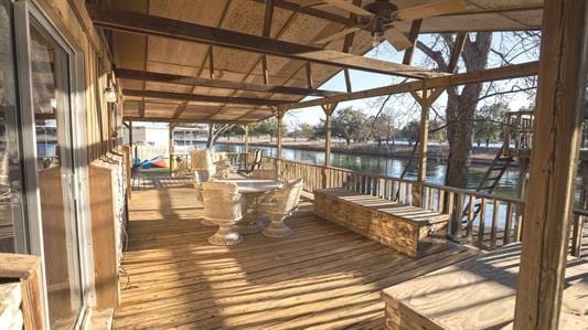 deck with a water view and ceiling fan