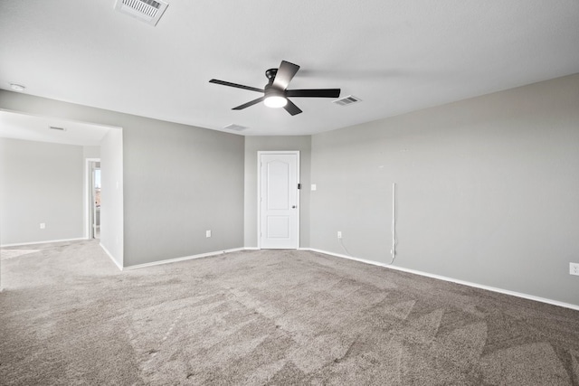 carpeted spare room with ceiling fan, visible vents, and baseboards