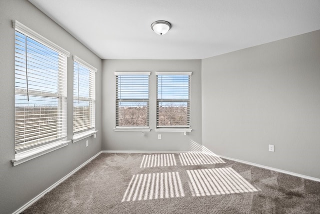 unfurnished room featuring carpet floors and baseboards