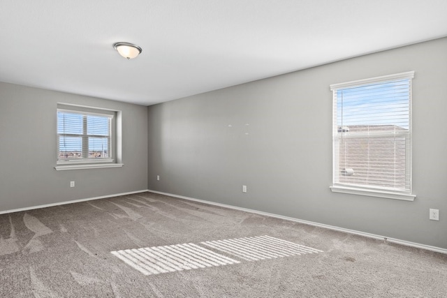 unfurnished room with carpet flooring and baseboards