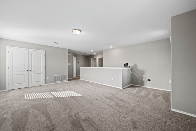 unfurnished room featuring light carpet, visible vents, and baseboards