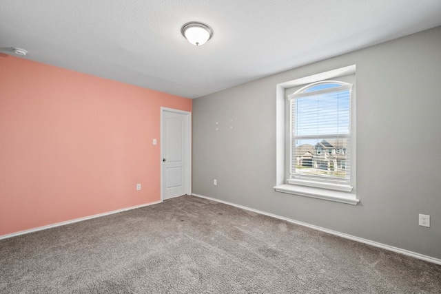 unfurnished room with carpet, a textured ceiling, and baseboards