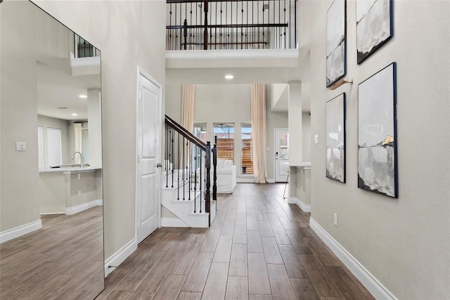 entryway with stairs, baseboards, and wood finished floors