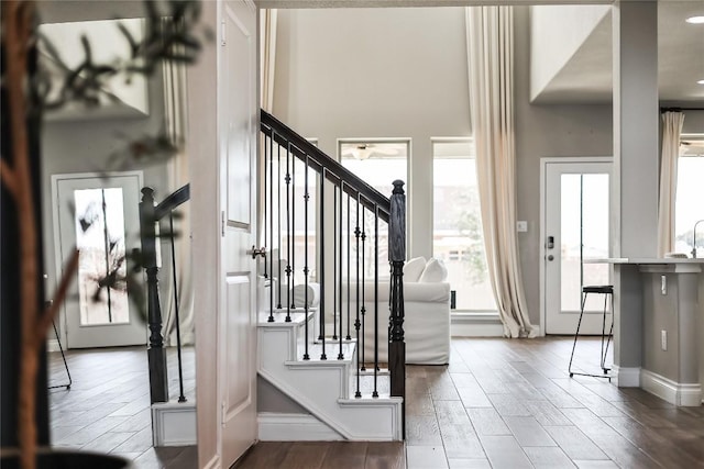 entrance foyer with wood finish floors, stairway, and baseboards