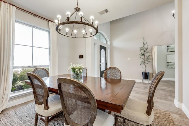 dining space with light wood-style flooring, visible vents, and baseboards