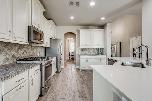 kitchen with visible vents, appliances with stainless steel finishes, white cabinets, and a sink