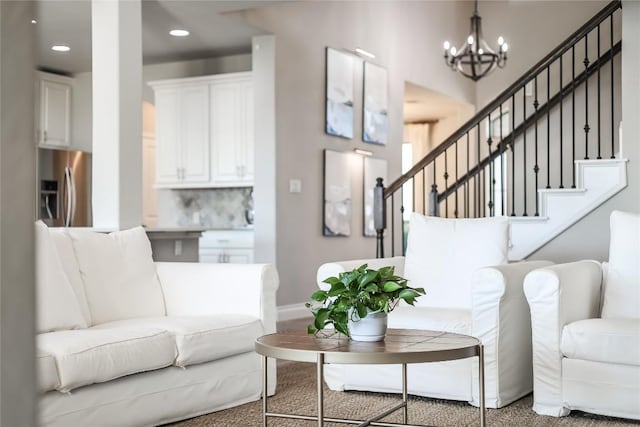 living area featuring a chandelier, stairway, carpet flooring, and baseboards