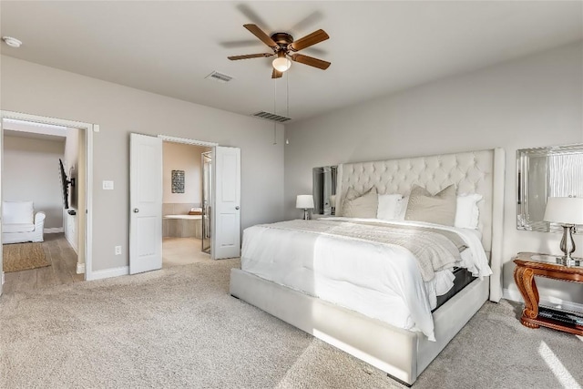 bedroom with light carpet, ensuite bath, visible vents, and baseboards